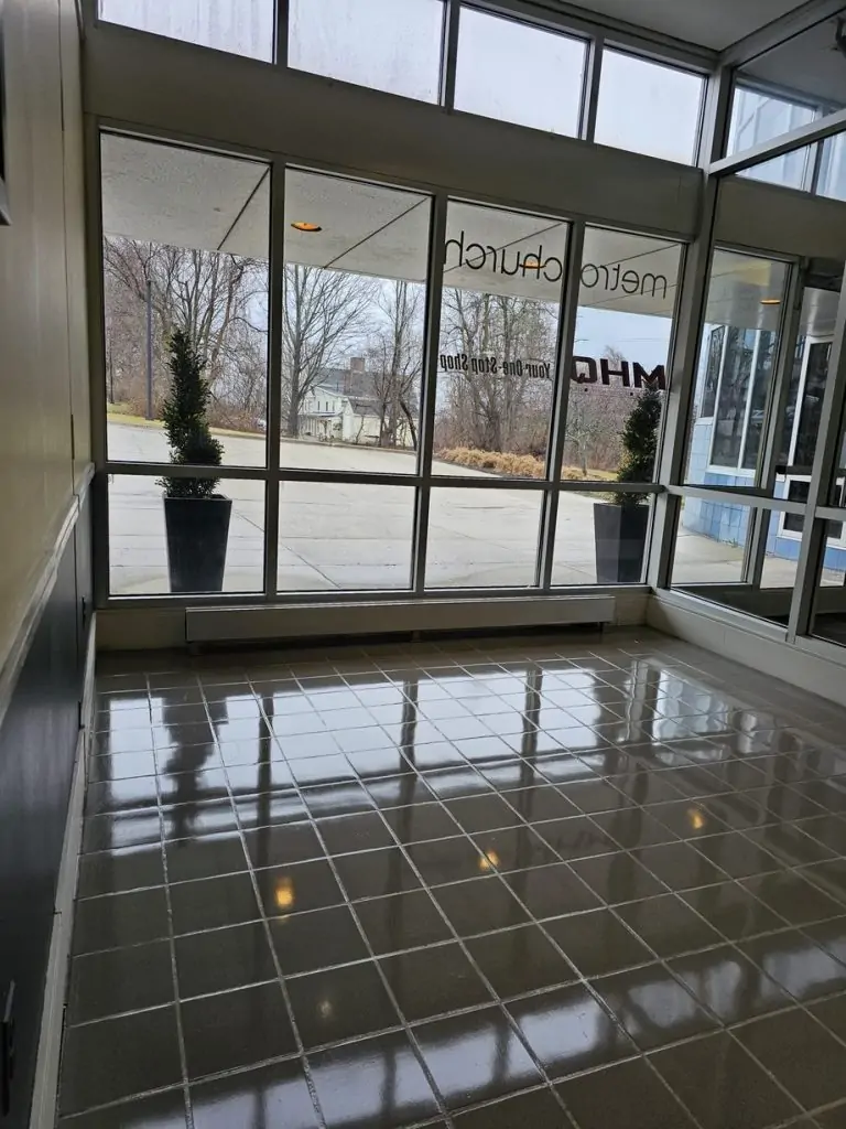 Polished tile floor with clean grout lines in a glass-walled commercial entry vestibule